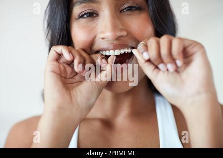 Lo faccia giornalmente per la salute dei vostri denti. Ritratto di una giovane donna bella e felice che le gallina i denti. Foto Stock