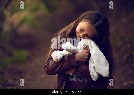 Ti amo tanto, OH, una giovane ragazza che abbraccia il suo orsacchiotto fuori. Foto Stock