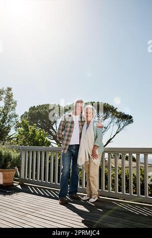 Le giornate continuano a migliorare e a migliorare. Una coppia felice e anziana si rilassa insieme nel patio di casa. Foto Stock