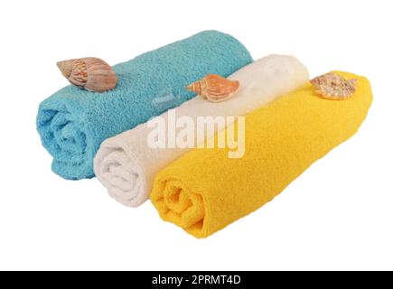Rotoli di blu, bianco, giallo asciugamani con conchiglie di mare isolato su bianco Foto Stock