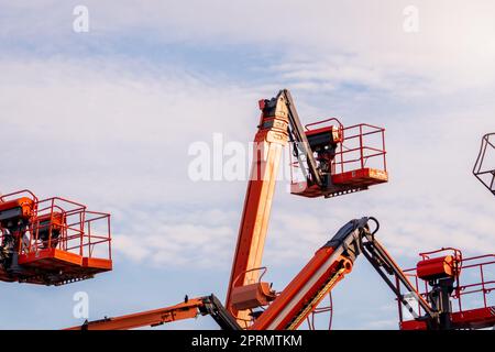 Sollevamento del braccio articolato. Sollevamento piattaforma aerea. Sollevamento del braccio telescopico contro il cielo blu. Gru da costruzione mobile da affittare e vendere. Manutenzione e riparazione del sollevamento del braccio idraulico. Concessionario gru. Foto Stock