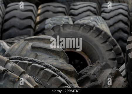 Primo piano pneumatici usati per autocarri. Rifiuti di pneumatici vecchi per il riciclaggio o per la discarica. Pneumatico in gomma nera del veicolo. Cumulo di pneumatici usati nel cortile di riciclaggio. Materiale per Foto Stock