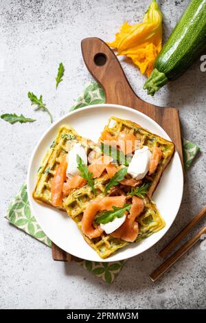 Waffle belgi con zucchine e verdure con formaggio cottage e salmone salato Foto Stock