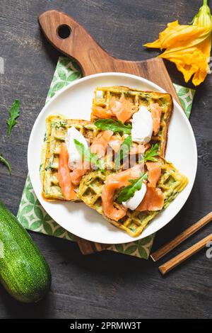 Waffle belgi con zucchine e verdure con formaggio cottage e salmone salato Foto Stock