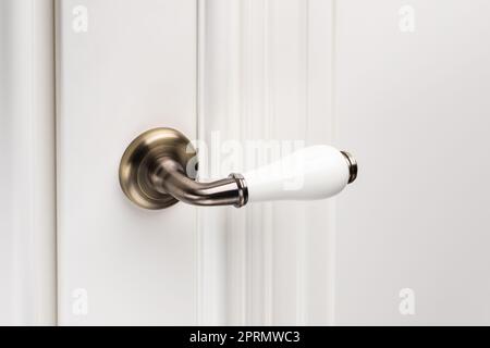 Primo piano dell'elegante pomello o della maniglia dello sportello bianco. Foto Stock