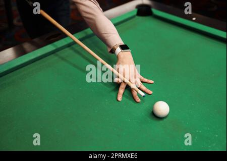 Primo piano ritratto di giovane uomo puntando con stecca da biliardo Foto Stock