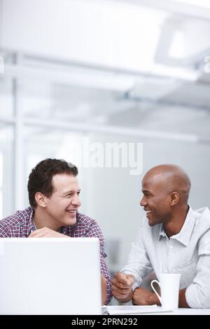 Credo che questa volta abbiamo fatto un ottimo lavoro. Due uomini d'affari che hanno una discussione mentre theyre seduto ad un tavolo con un laptop. Foto Stock