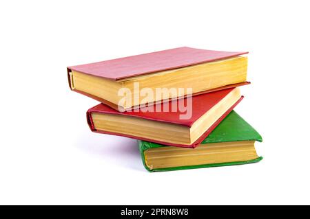 Una pila di vecchi libri con copertine colorate. Libri per la lettura. Vecchio libro. Pagina del libro di carta gialla. Sfondo bianco. Prodotto cartaceo. Leggere la documentazione. BA Foto Stock
