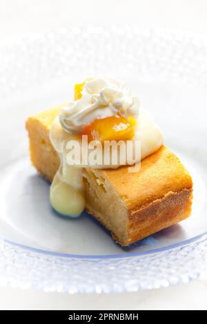 pan di spagna con crema alla vaniglia, pesca e panna montata Foto Stock