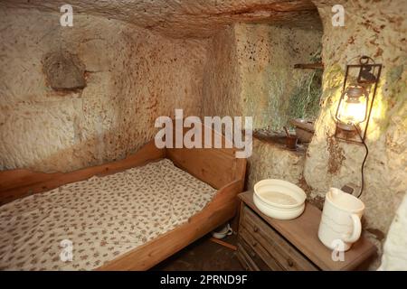 Langenstein, Germania. 13th Apr, 2023. Vista nella camera da letto di una dimora grotta. Questa dimora grotta si trova sul Schäferberg. Le abitazioni nelle grotte di Langenstein sono state scolpite in morbida pietra arenaria dai lavoratori migranti tra il 1855 e il 1858. Dieci di queste abitazioni sono state conservate e alcune sono aperte ai visitatori. Circa 12.000 visitatori interessati hanno visto questa testimonianza unica della cultura della prima vita individualmente o con un tour guidato nel 2022. Ora ci sono visite guidate settimanali fino alla fine di settembre. Credit: Matthias Bein/dpa/Alamy Live News Foto Stock