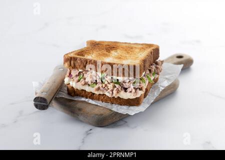Panino di tonno con mayo e verdure su marmo bianco Foto Stock