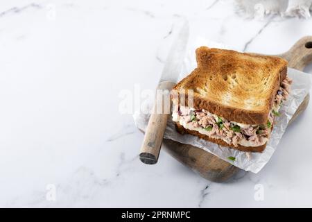 Panino di tonno con mayo e verdure su marmo bianco Foto Stock
