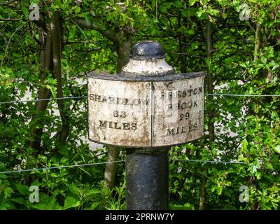 Segnale in ghisa sul canale di Trent e Mersey vicino a Stoke-on-Trent in Inghilterra che mostra la distanza da Shardlow e Preston Brook. Foto Stock