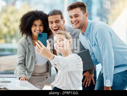 Selfie di lavoro di squadra, telefono e persone giocose o divertenti per i social media, contattaci o pagina del sito Web chi siamo. Sorriso felice o diversità creativa donne d'affari o amici d'ufficio con la tecnologia della fotografia mobile Foto Stock