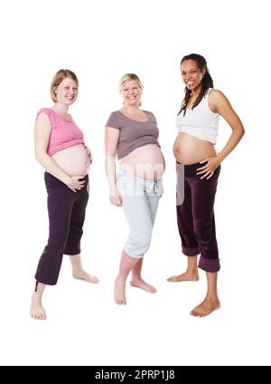 Ritratto di felice incinta, donna e amici in una foto di gruppo su sfondo bianco dello studio. Le donne nella diversità sorridono con i piccoli urti o la pancia in piedi nella felicità di essere una madre in mockup. Foto Stock