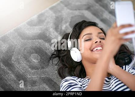 Momenti melodici. Una giovane donna che ascolta musica a casa. Foto Stock