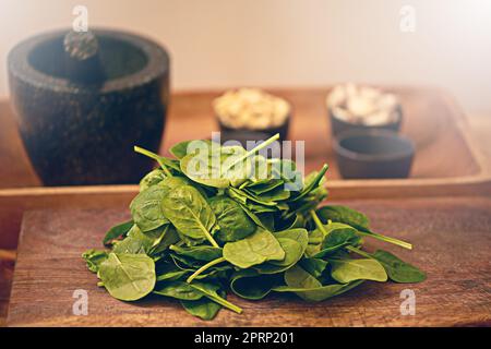 Direttamente dal giardino alla cucina. Foglie di basilico fresco su un tavolo da cucina. Foto Stock