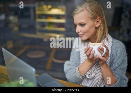Abbiamo tutti bisogno di un posto per essere soli. Una giovane donna seduta in una caffetteria. Foto Stock