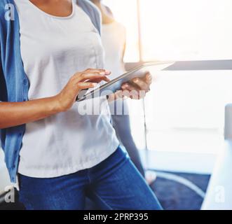 Lo strumento aziendale perfetto per i professionisti moderni. Una donna d'affari che utilizza un tablet digitale in ufficio. Foto Stock