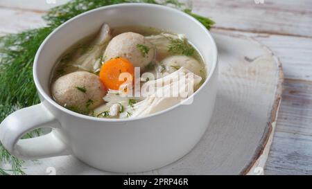 Pollo Matzo sfera zuppa con carote nel recipiente. Tradizionale ebraico per le vacanze di Pasqua cibo Foto Stock