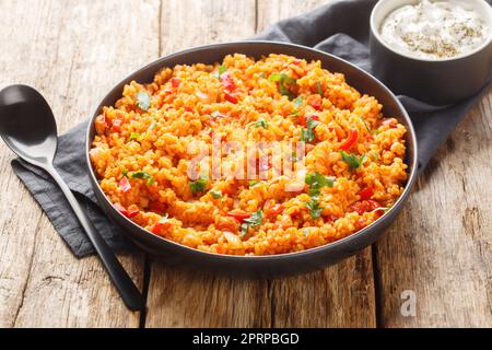 Pilaf turco da bulgur con verdure e spezie primo piano in una ciotola su un tavolo di legno. Orizzontale Foto Stock