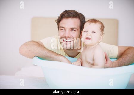 HES un tale padre doting. Un giovane padre si lega con la figlia del bambino in bagno. Foto Stock