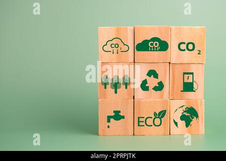 blocco di legno cubo icona co2 carbon credit e eco energia verde tecnologia su sfondo verde. Foto Stock