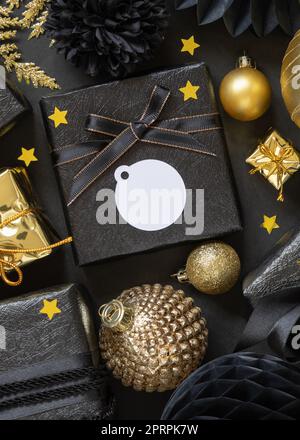 Scatole regalo e ornamenti natalizi dorati e neri, etichetta regalo rotonda Mockup Foto Stock