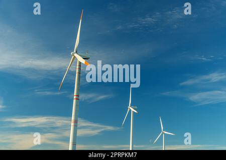 Energia verde su turbine eoliche e turbine eoliche. Fonti energetiche alternative e fonti energetiche rinnovabili. Generazione di energia elettrica e generatori di centrali elettriche. Parco eolico ed eolico, conservazione ambientale Foto Stock