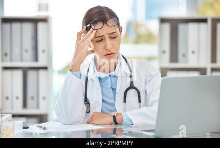 Mal di testa stress, dottore burnout e infermiera triste che lavora su laptop in ufficio di lavoro in ospedale, stanco di consulenza in assistenza sanitaria e ansia da chirurgia medica. Lavoratore con depressione alla clinica Foto Stock