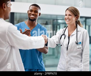 Stretta di mano con i medici in un ospedale, clinica o struttura medica per un buon lavoro, successo o approvazione. Assistenza sanitaria, salute e grazie, stringere la mano o applaudire, congratulazioni o benvenuto a bordo. Foto Stock