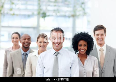 Guidato con gli obiettivi in mente. I diversi team aziendali si trovano in una posizione di sicurezza con il loro team leader, CopySpace. Foto Stock