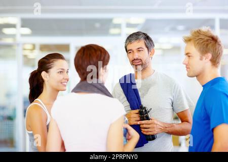 Stile di vita sano. Ritratto dell'uomo in forma che parla con gli amici dopo l'allenamento in palestra. Foto Stock