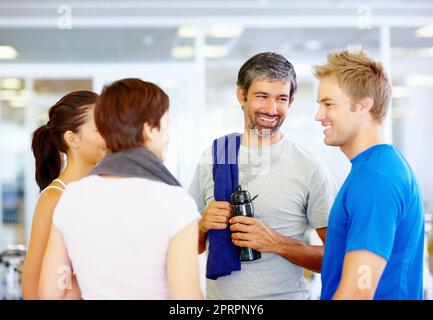 Gruppo di amici in palestra. Uomo maturo che parla con gli amici dopo l'allenamento in palestra. Foto Stock