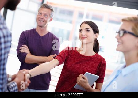 Facendola sentire Benvenuto. due colleghi che scuotono le mani. Foto Stock