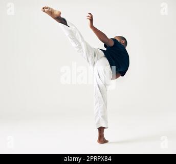 Essere diversi. Studio di un giovane artista marziale che pratica. Foto Stock