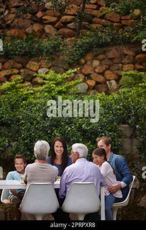 Tempo di qualità. Una famiglia multi-generazionale felice che ha un pasto insieme fuori. Foto Stock