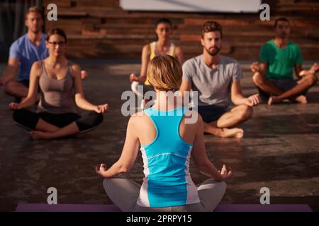 Zona senza stress. Un istruttore di yoga che istruisce la sua classe. Foto Stock