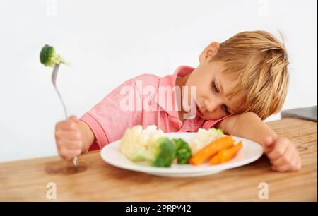 Non mi piacciono i veggies. Un ragazzino molto insoddisfatto di dover mangiare verdure. Foto Stock