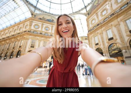 Sorridente fashion girl autoritratto in Milano shopping gallery and landmark, Milano, Italia Foto Stock