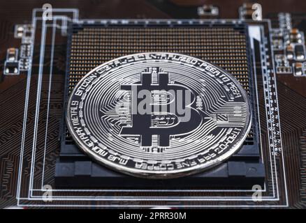 Monete d'argento bitcoin criptovaluta sul circuito stampato Foto Stock