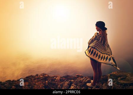 Gli shes hanno avuto uno spirito vagabondante. una giovane donna felice che ammira una vista dalla nebbia dalla cima di una montagna Foto Stock