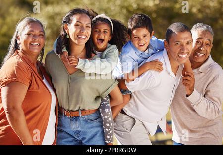 Famiglia numerosa, tre generazioni e persone felici che condividono amore, cura e un legame speciale mentre si trovano al parco in una giornata di sole. Ritratto di bambini, genitori e nonni in un'avventura divertente in messico Foto Stock