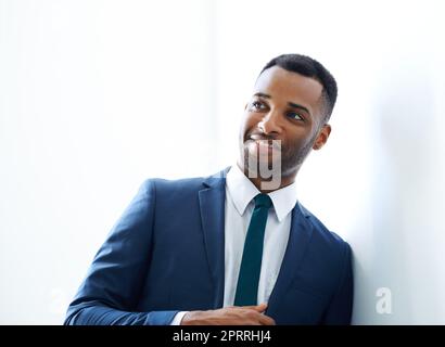 Ive ha ottenuto un giorno occupato avanti... Un giovane uomo d'affari afroamericano bello in piedi all'interno. Foto Stock