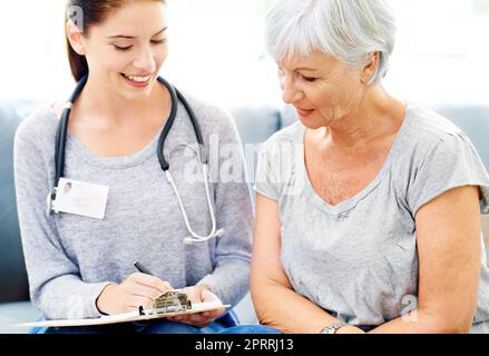 Questi risultati sono eccellenti. Un medico che spiega i risultati positivi del test a un paziente anziano sorridente. Foto Stock