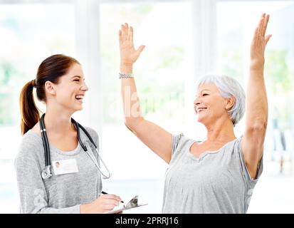 I test sono stati negativi. Un medico che spiega i risultati positivi del test a un paziente anziano molto felice. Foto Stock