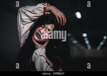 Horror, donna assetata di sangue, fantasma o zombie, è spaventosa e si rompe il collo Foto Stock