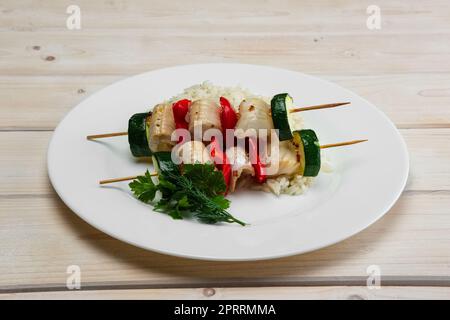 Grigliate di pesce e di verdure su spiedino con riso bollito Foto Stock