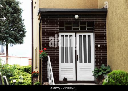 Splendidi fiori e piante verdi sul portico casa Foto Stock