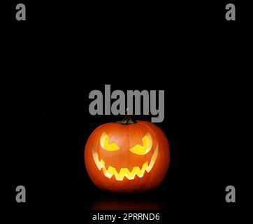 Vista ravvicinata della spaventosa zucca di Halloween con gli occhi che si illuminano all'interno Foto Stock